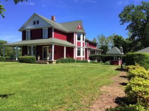 a red house with a lawn in front of it at Plain & Fancy Bed & Breakfast in Ironton