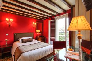 a red bedroom with a bed and a window at Hotel Des Deux Continents in Paris