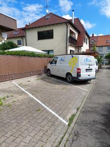 una furgoneta blanca estacionada en un estacionamiento en Fremdenzimmer Familie Förster, en Villingen-Schwenningen