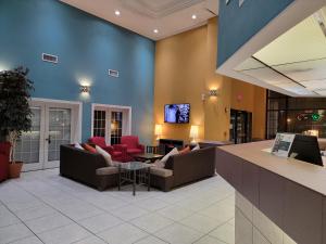 阿馬里洛的住宿－Extend-a-Suites - Extended Stay, I-40 Amarillo West，大堂配有沙发和墙上的电视