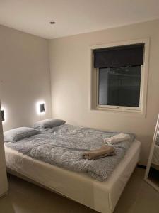 a bedroom with a bed with a window and a towel on it at Ulriken Apartment in Bergen