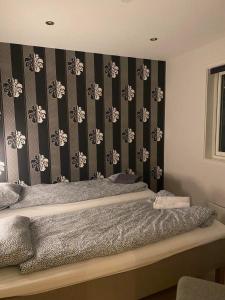 a bedroom with a bed with black and white wallpaper at Ulriken Apartment in Bergen