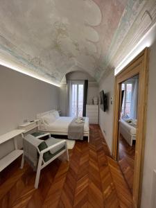 una camera con letto e soffitto con un dipinto di Arco Antico ad Alba