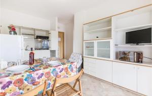 アルバ・アドリアティカにあるAmazing Apartment In Villa Rosa Te With 2 Bedroomsのキッチン(ダイニングルームテーブル、テレビ付)