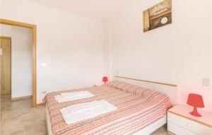 アルバ・アドリアティカにあるAmazing Apartment In Villa Rosa Te With 2 Bedroomsのベッドルーム1室(ベッド1台、タオル2枚付)