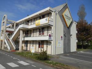 a large white building with a staircase in front of it at Premiere Classe Brest Gouesnou Aeroport in Brest