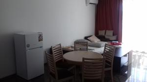 ソゾポルにあるApartments Kaloyanのキッチン(テーブル、椅子、冷蔵庫付)