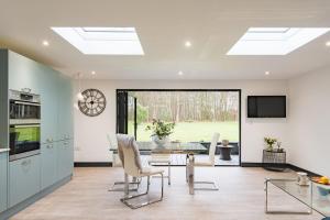 a kitchen and dining room with a glass table and chairs at Little Seven Oaks by Bloom Stays in Kingswood