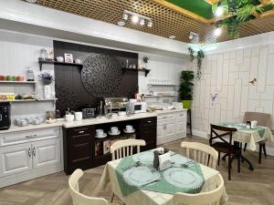 a kitchen with a table and chairs in a kitchen at Abazhur Hotel in Tomsk