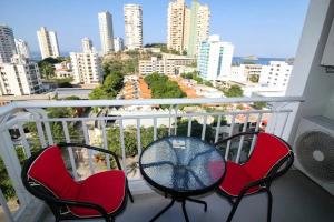 2 sillas y mesa en un balcón con vistas en Apartamentos Reserva de la Sierra - by Bedviajes, en Santa Marta