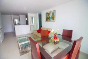 a dining room with a table and chairs and a living room at Apartamentos Reserva de la Sierra - by Bedviajes in Santa Marta