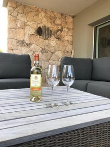 a bottle of wine sitting on a table with two wine glasses at Villa BOREA in Golfo Aranci +52 photos