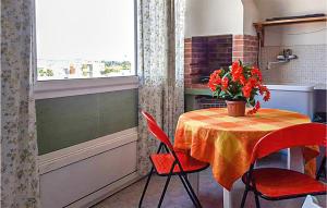 una cucina con tavolo e vaso di fiori di 1 Bedroom Beautiful Apartment In Gallipoli a Foča