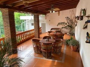 a patio with tables and chairs on a balcony at Hostal Casa Blanca in Comala