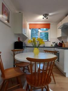 a kitchen with a table with a vase of flowers on it at Woodland Retreat in Uny Lelant