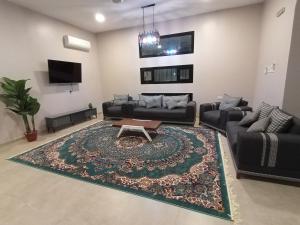 uma sala de estar com um sofá e uma mesa de centro em استراحة النيروز em Al Hadd