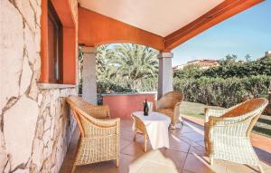 un patio con sillas de mimbre y una mesa en Beautiful Home In Costa Rei -ca- With Kitchen, en Monte Nai