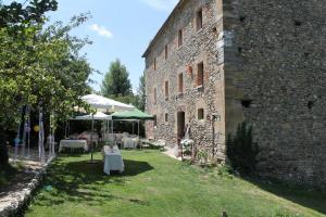 Un jardín con mesas y sillas frente a un edificio. en REST LIFE EL SALTO, en Belorado