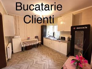 Il comprend une cuisine équipée d'un réfrigérateur noir et de placards blancs. dans l'établissement Pensiunea Ianis Piatra Neamt, à Piatra Neamţ