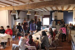 grupa ludzi siedzących przy stolikach w pokoju w obiekcie REST LIFE EL SALTO w mieście Belorado