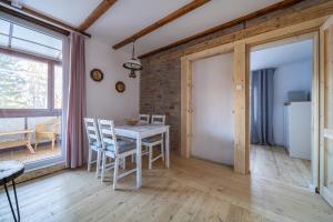 een eetkamer met een witte tafel en stoelen bij Apartament Rosa in Szklarska Poręba