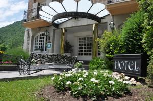 a black bench in front of a house with flowers at Hotel Edelweiss in Camprodon +34 photos