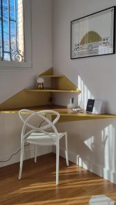a desk with a chair and a laptop on it at Au 53, sous le chartil in Reims
