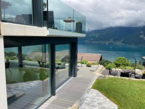 a glass house with a view of the water at Moderne Unterkunft mit Panoramablick auf Thunersee in Krattigen