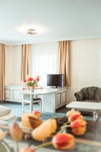Hotel Limmerhof في توفكيرتشين: غرفة معيشة مع طاولة وتلفزيون