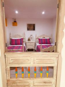 a bedroom with two beds with colorful pillows at Casa Familiar María E in Filandia +44 photos