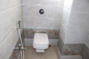 a small bathroom with a toilet and a shower at Hotel Angina in Kolkata