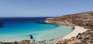 Blick auf einen Strand mit blauem Wasser in der Unterkunft LE VILLETTE DI TERRANOVA in Lampedusa
