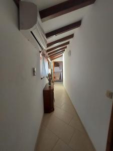 a hallway with white walls and a ceiling with wooden beams at Apartments Božena in Pakoštane