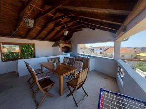 a dining room with a table and chairs on a balcony at Apartments Božena in Pakoštane