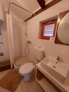 a white bathroom with a toilet and a sink at Apartments Božena in Pakoštane