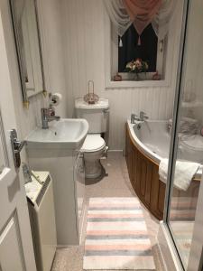 a bathroom with a tub and a toilet and a sink at Skerrols in Broadford +56 photos