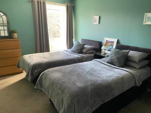 a bedroom with two beds and a window at The Number Eleven Apartment in Kilmuir