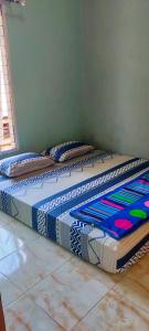 Mandeh Guesthouse Padang في بادانج: وجود سرير على الارض في غرفة