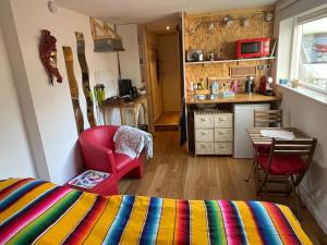 a room with a bed and a table and a kitchen at Studio 7 in Hoogland