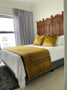a bedroom with a large bed with yellow pillows at 417 The Sandown in Cape Town +26 photos