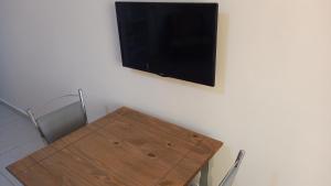 a wooden table with a flat screen tv on a wall at Atlantica Suites in Guarujá