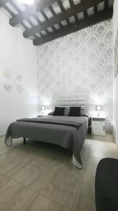 um quarto branco com uma cama grande e 2 mesas em Apartamento Levante em Cádis