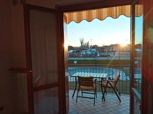 a patio with a table and chairs on a balcony at Mosaici Sunrise - lake front apartment with beautiful view in Sirmione