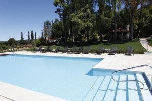 a large swimming pool with chairs and a house at Parador Casa Da Insua in Penalva do Castelo