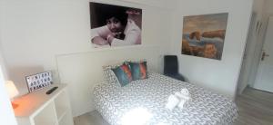 a white bedroom with a bed with a white doll on it at Prau Riu Hotel Hyundai-Asturdai in Llanes