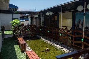 eine Terrasse mit Bänken und einem Teich im Gras in der Unterkunft Eco Hotel in Navegantes