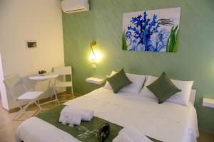 ein Schlafzimmer mit einem großen weißen Bett und einem Tisch in der Unterkunft Corallo Rosso B&B in Terrasini