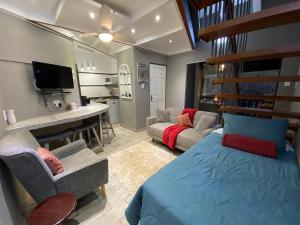 a bedroom with a bed and a living room at Boomhuisie in Komatipoort