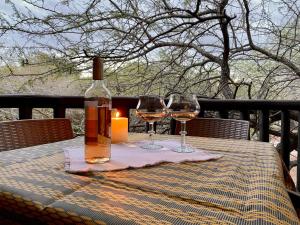 a bottle of wine and two glasses on a table at Boomhuisie in Komatipoort