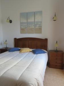 - une chambre avec un lit et 2 oreillers bleus dans l'établissement Casa do Quintalão, à Raposeira